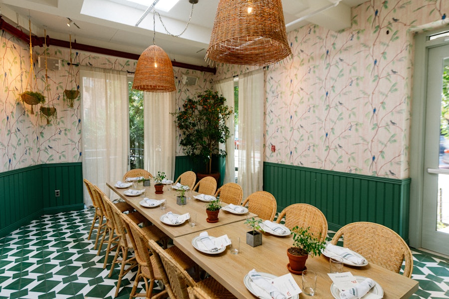 A private dining room at Rosemary's East set with one long table in the center of the room.