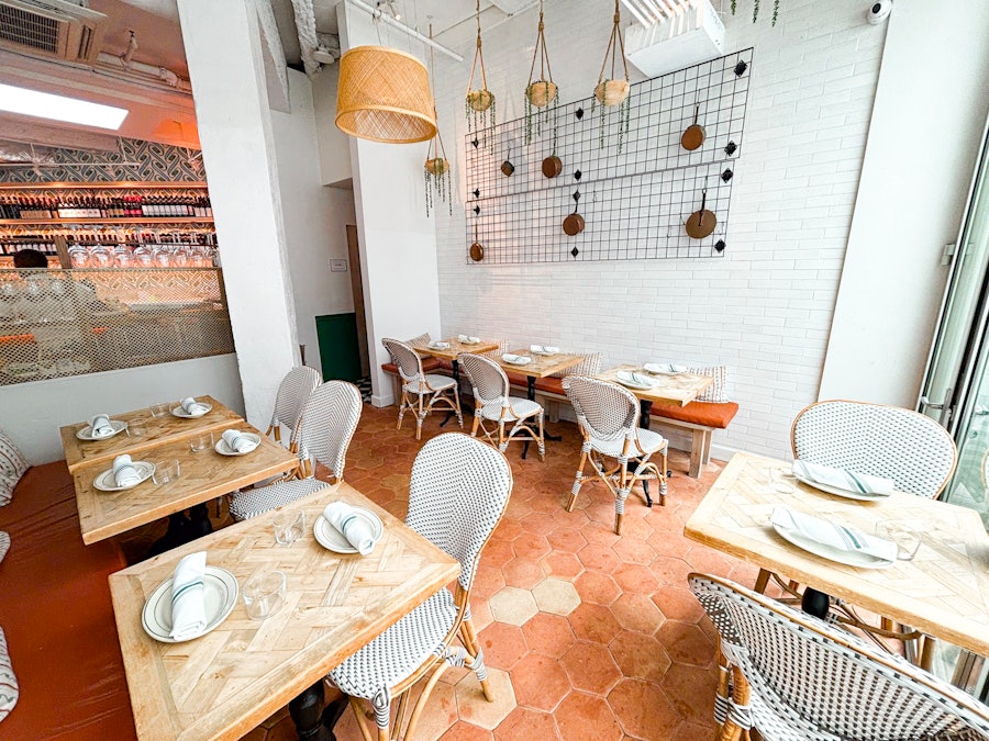 A secluded area of the dining room at Rosemary's East with multiple tables.