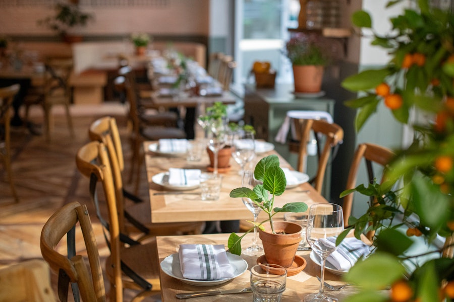 The tables along the windows at Rosemary's Midtown, as set up for service.